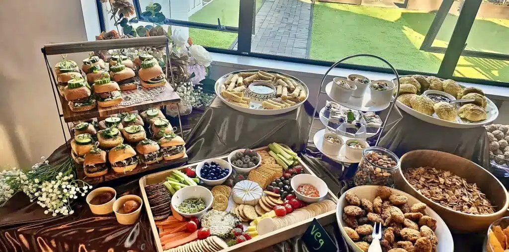 A Kacks grazing table with slider towers, crackers, dips and savoury bites by a sunny window