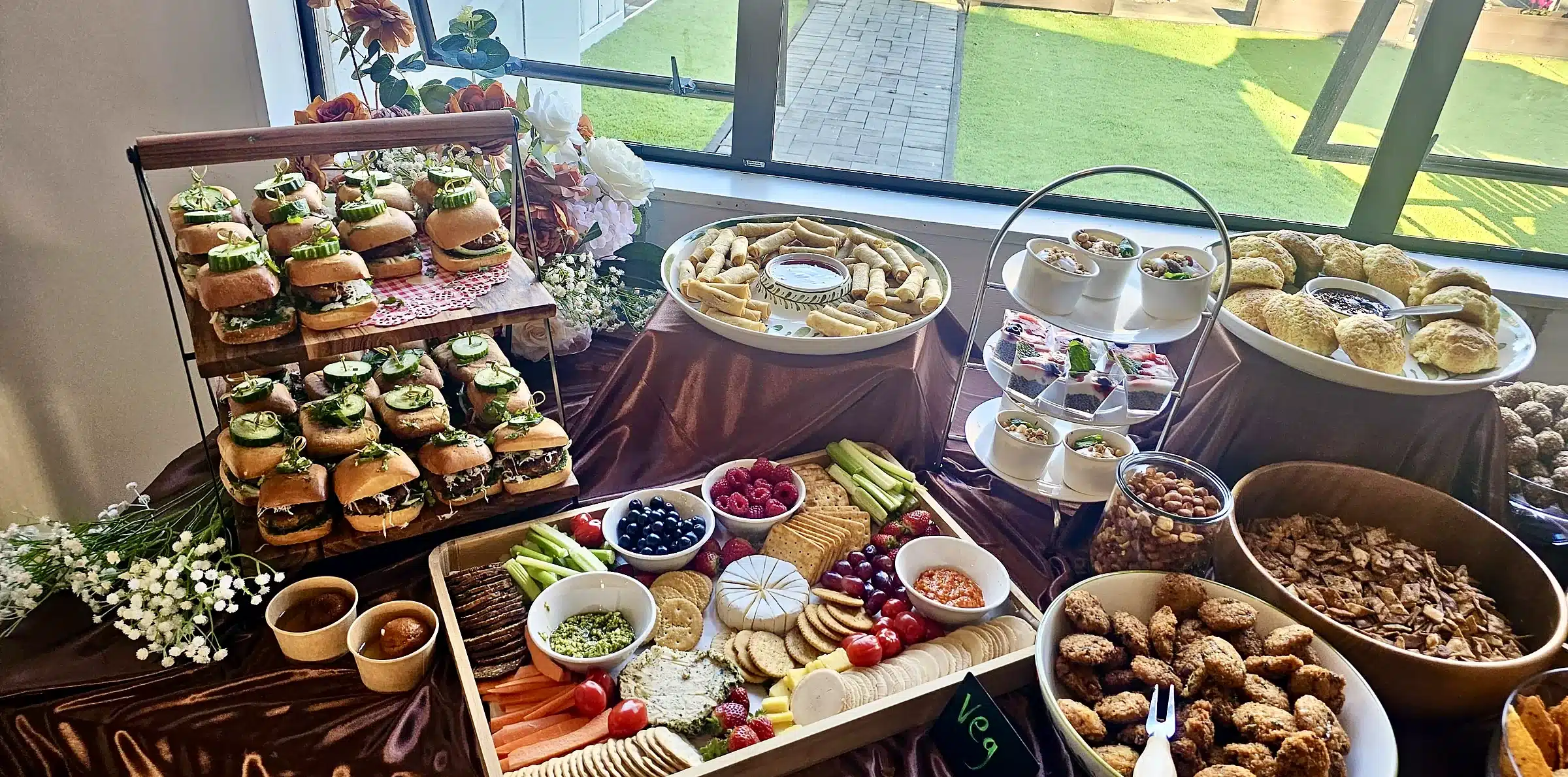 A Kacks grazing table with slider towers, crackers, dips and savoury bites by a sunny window